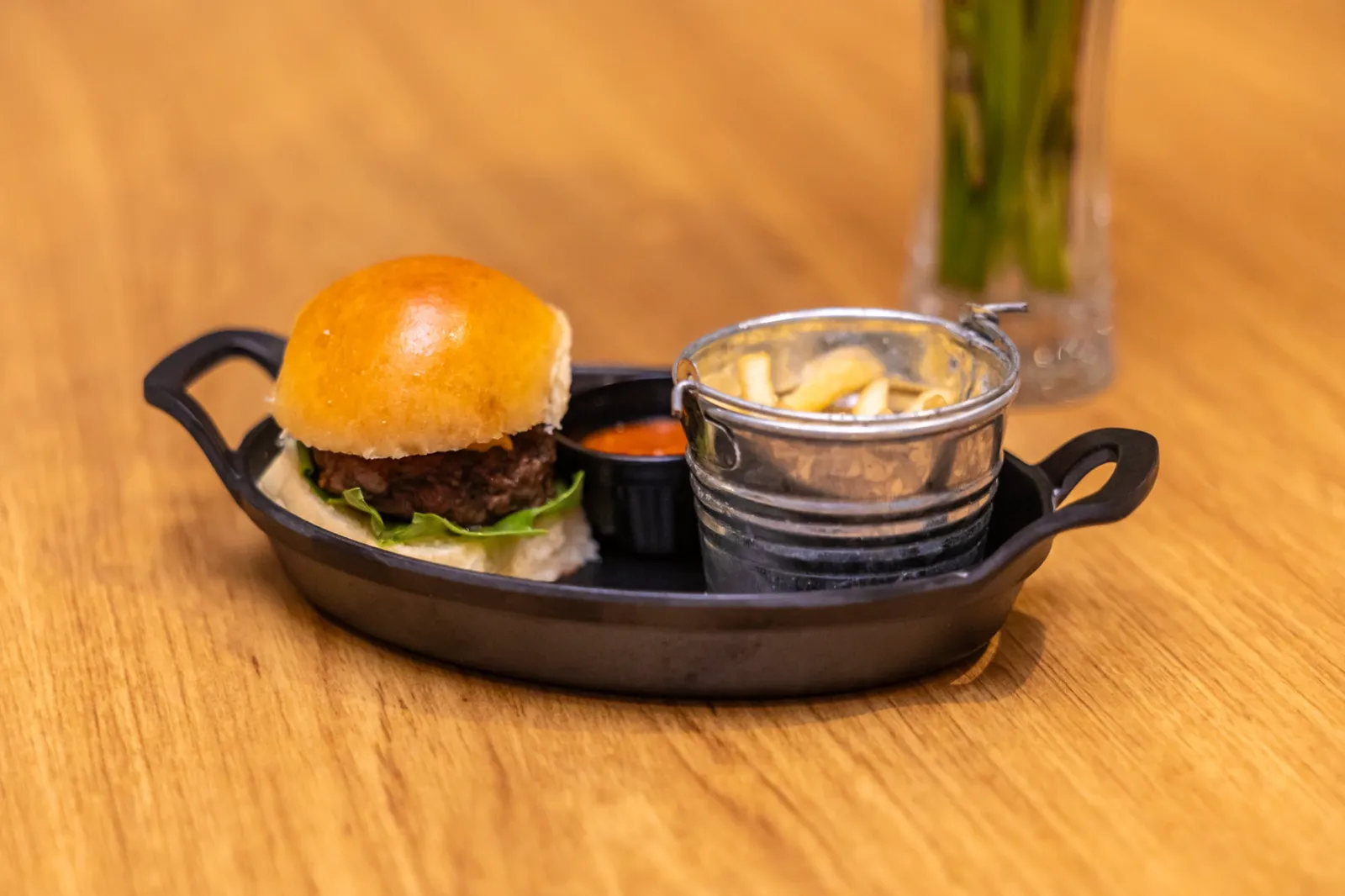 Mini hambúrguer com batatinhas servido na cesta de metal