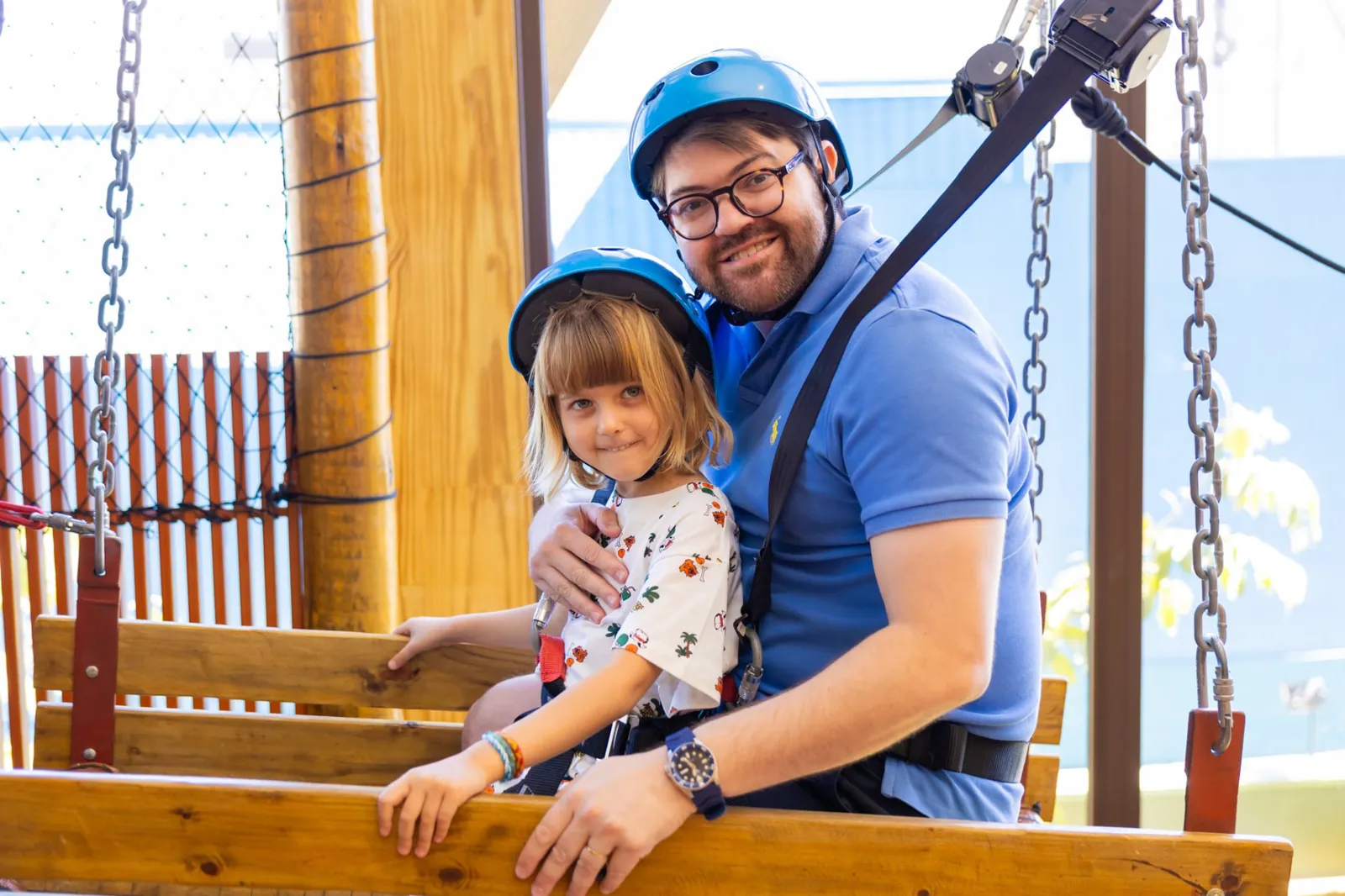 Pai e filha com capacete no circuito aéreo do espaço